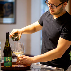 Oliver schenkt Wein in Gläser