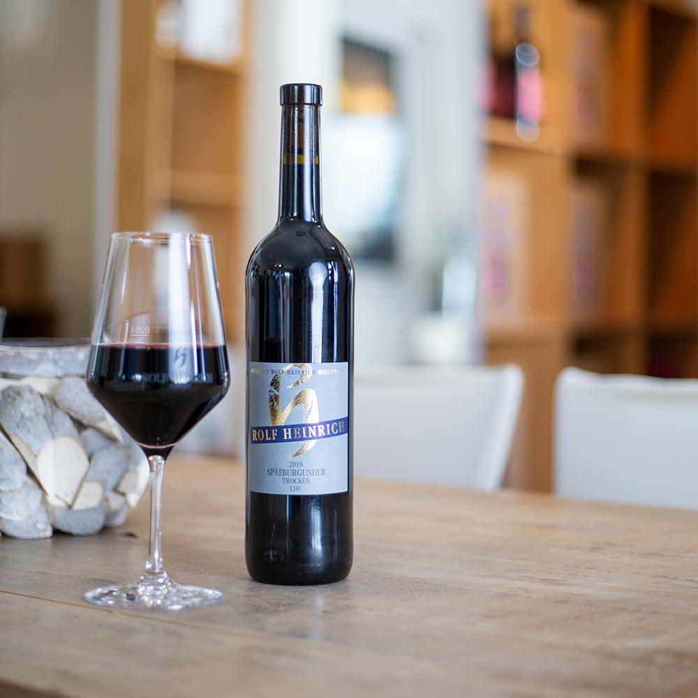 Flasche Rotwein mit Glas auf Holztisch